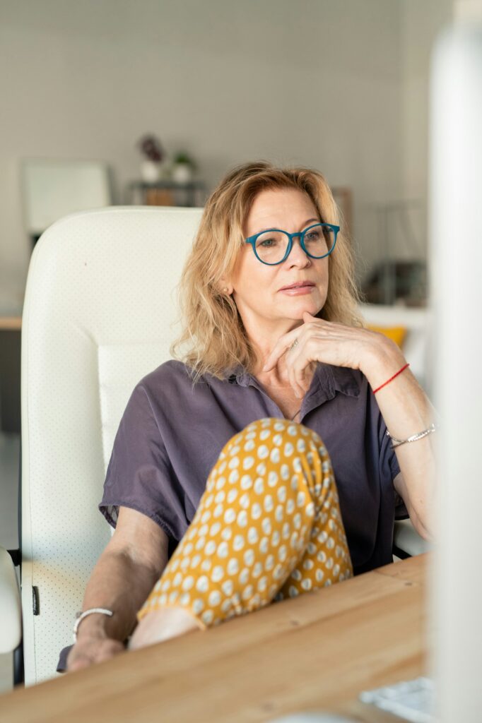 Creative mature businesswoman or web designer looking at computer screen